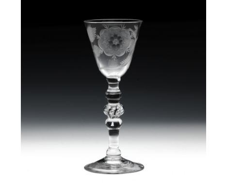 A Jacobite light baluster wine glassCirca 1750The round funnel bowl engraved with a six petalled rose flanked by a bud, on a 