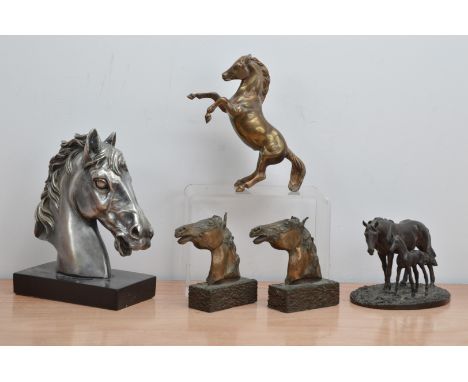 A collection of horse sculptures, comprising a silvered horse bust on a rectangular stand 25cm high, a pair of cast metal hor