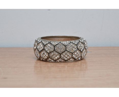 An unmarked silver coloured diamante bracelet bangle 