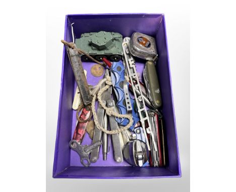 A group of Swiss Army and other knives, pocket scale, multi-tool, Corgi die-cast tank, Stanley tape measure, etc.