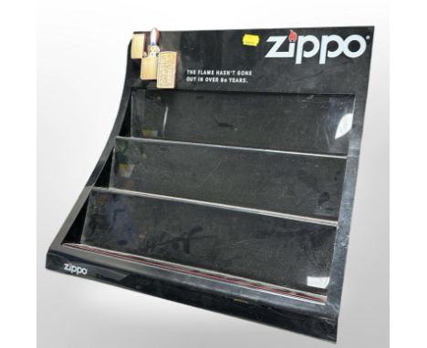 A Zippo lighter plastic display stand, width 39cm. CONDITION REPORT: Chip to upper corner.