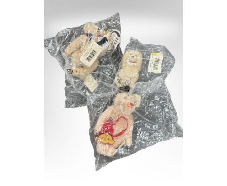 Three Steiff teddy bears, sealed in retail cellophane packaging including girl teddy bear with tennis racket, boy with runnin