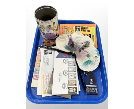A tin of vintage glass marbles, stamps and first day covers, police epaulets, I-Spy books, oriental hand fan etc 