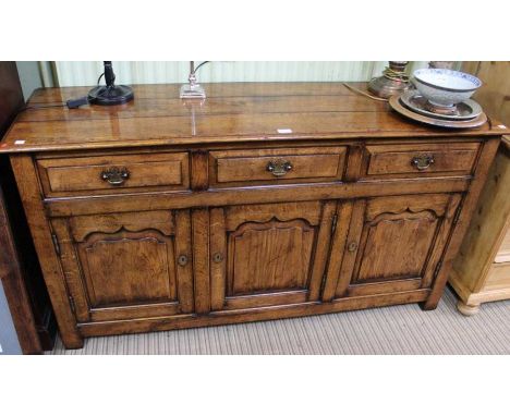 An 18th century design oak dresser base, three inline drawers over three cupboard doors, 81cm x 153 cm