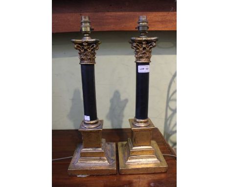 A pair of black &amp; gold column table lamps