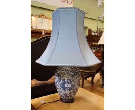 A blue porcelain table lamp with wooden base and shade.&nbsp;