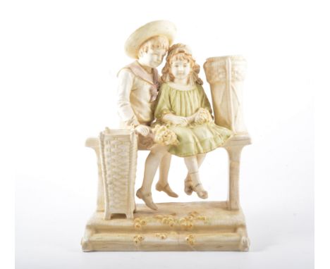 Ernst Wahliss, pottery group of boy and girl on a garden bench, with spill vase aperture, height 32cm.