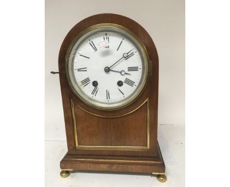 A mahogany mantle clock with an enamel dial and brass mounted case no pendulum.
