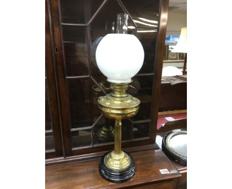 A brass oil lamp with a white glass shade, approx total height 68cm.