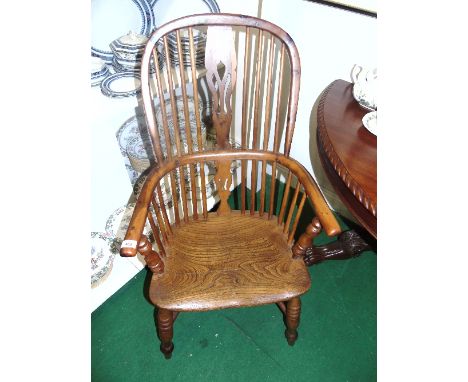 An Early 19th Century Irish Elm and Yew Wood Stick Back Windsor Elbow Chair with pierced vase splat on turned legs with cowho