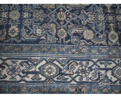 A Persian Runner having a central pole medallion surrounded by stylised foliate designs on a blue ground 500 x 100cm