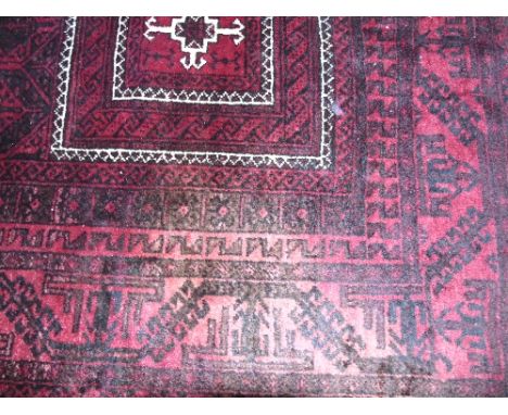 A Persian Style Red Wool Carpet with geometric detail upon a red ground, within further running borders, 200 x 105 cm