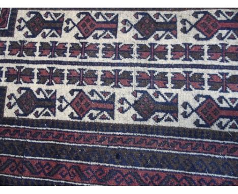 A Persian Baluchi Tribal Rug, borders enclosing a central panel. 