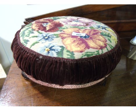 A 19th Century Foot Stool, having a floral tapestry top standing on three shallow bun feet.