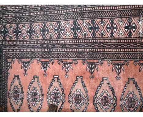 An Afghan Wool Runner with multi-medallion centre upon a salmon coloured field, within geometric borders, 165 x 95 cm