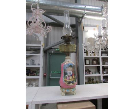 A porcelain oil lamp with classical scenes and amber glass font
