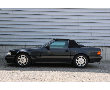 The 1993 Mercedes SL 320, presented in a sophisticated Dark Grey Metallic, is an elegant convertible that comes with a hardto