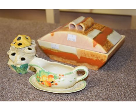 A Clarice Cliff Sungay Bizarre flower holder, a Wilkinson Honeyglaze sauce-boat and stand, and a butter dish and cover (3) 