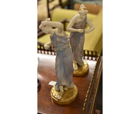Two Royal Worcester figurines of maidens, classically draped, modelled in the manner of James Hadley, puce marks one numbered
