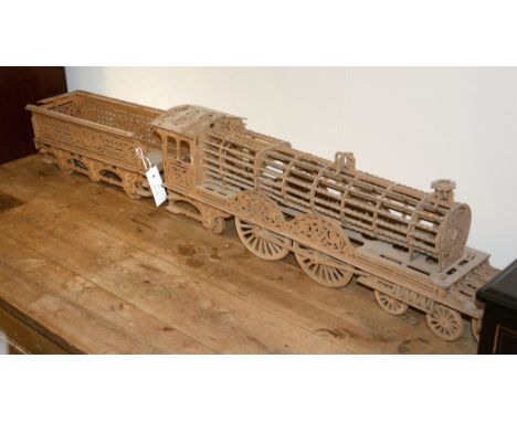 A pierced wooden model of a train pulling a tenderThis lot is to be sold without reserve. 