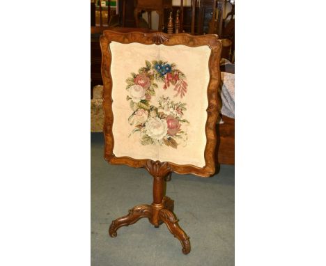 A Victorian carved walnut firescreen with needlework panel, 136cm high overall 