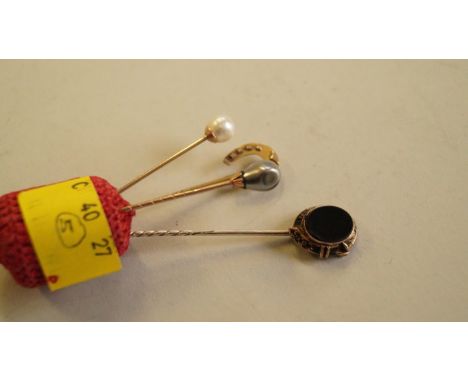 An unmarked yellow metal mourning stick pin; together with three other various stick pins. [4]
