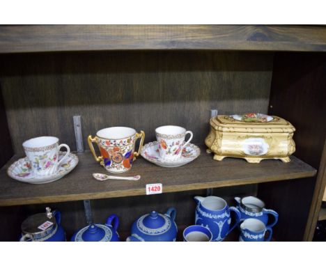 An early 19th century English porcelain twin handled Imari cup; together with a pair of Dresden porcelain cups and saucers; a