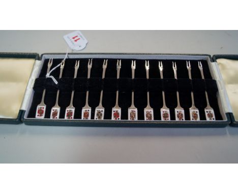 A cased set of twelve silver and enamel cocktail forks, by Garrard & Co. Ltd., Birmingham 1961, each terminal decorated with 