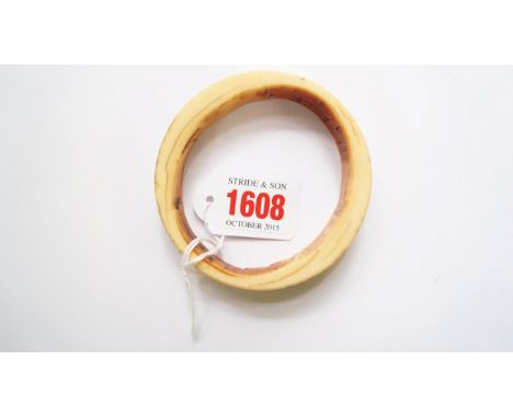 An old ivory bangle, with circular punched decoration.