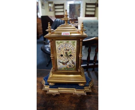 A late 19th century gilt brass and porcelain mounted mantel clock, painted with goldfinches, 34cm high, on giltwood stand. 
