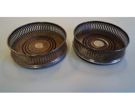 A pair of silver bottle coasters, by C S R Ltd., London 1988, with pierced sides, 12.5cm diameter.