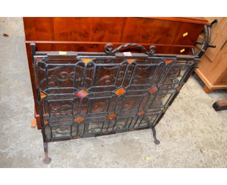 An early 20th century wrought iron and stained leaded glass firescreen, 77cm wide. 