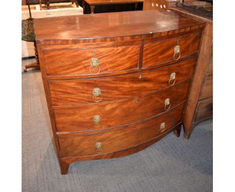 A George III mahogany bowfront chest of drawers, with two short and three long drawers each with lion mask ring handles, 104c