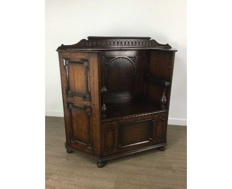 OAK HALL CUPBOARD / SETTLE, EARLY 20TH CENTURY  with raised moulded top rail over an arcaded panelled back, and swept arms on