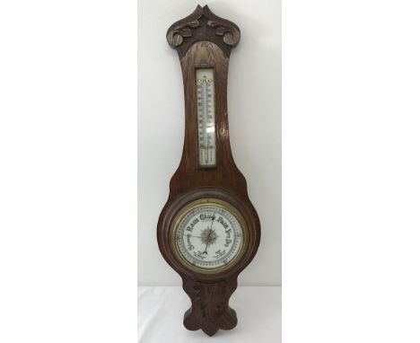 A vintage oak cased barometer and thermometer with carved detail to front.Approx. 65cm tall.