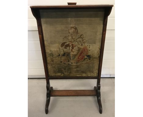 An antique mahogany framed fire screen with tapestry panel of a young girl and lamb.Small shelf and panel handle to top.Appro