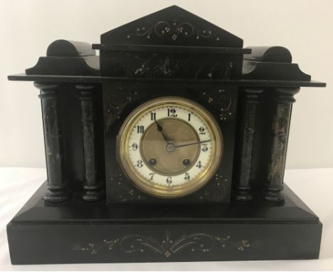 A vintage black slate and marble mantle clock with column detail to front, shaped top &amp; gilt detail.Enamelled outer rim t