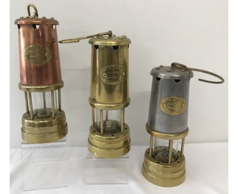 3 vintage brass miners lamps with "Lamp &amp; Limelight Company, Hockley" name plates.One with copper finish and one with sta