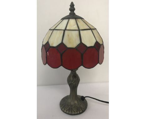 A small Tiffany style table lamp with Art Nouveau style base and cream and red glass shade.Approx. 36cm tall.