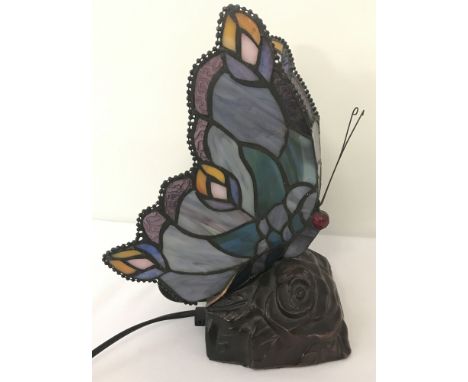 A small Tiffany style table lamp in the shape of a butterfly with leaded glass wing shades.Glass to base of one wing a/f.Appr