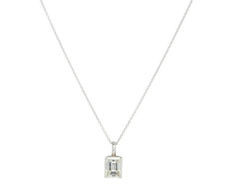 A single stone diamond set pendant  claw set with a single emerald cut diamond, to a 9ct gold trace link chain; with accompan