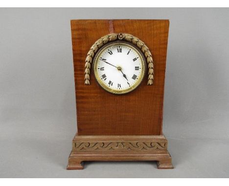 A mantel clock with carved detailing to the case, Roman numerals to enamel dial and French movement, with key.