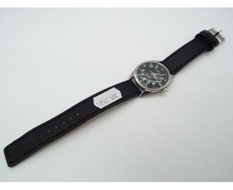 A military style wristwatch, black dial with green numerals marked hmt, manual wind 17 jewel movement, screw back, mounted on