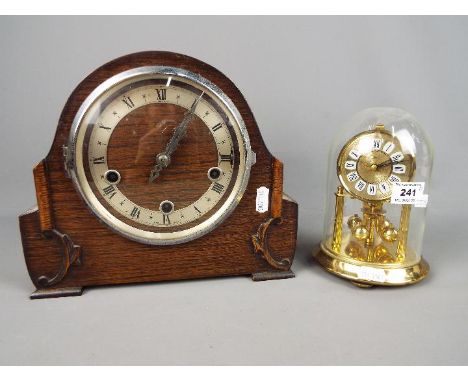 An Enfield oak cased mantel clock, Roman numerals to a silvered chapter ring, with key and pendulum and a German anniversary 