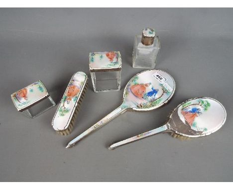 A George VI dressing table set comprising a silver and enamel backed mirror and three dressing table pots with silver, enamel