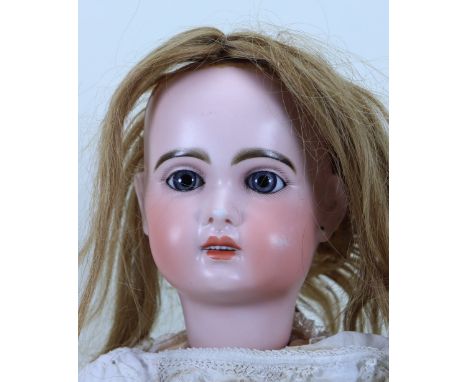 A Tete Jumeau bisque head Bebe, French 1895, with fixed blue glass paper-weight eyes, finely painted lashes and feather brows