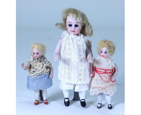 A miniature all-bisque doll and two others, German circa 1890, with fixed blue glass eyes, closed mouth and blonde wig, swive