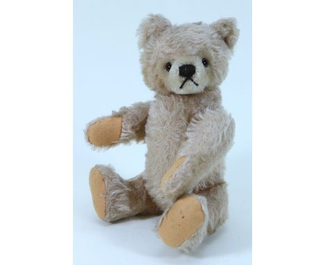 A post-war blonde mohair Steiff Teddy bear, straw filled bear with brown glass eyes, brown stitched nose and mouth, swivel he