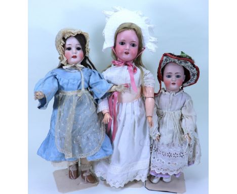 A Max Handwerck ‘Bebe Elite’ bisque head girl doll and two others, German circa 1910, with weighted brown glass eyes, open mo