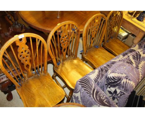 A set of four elm seated stick and wheel back kitchen chairs